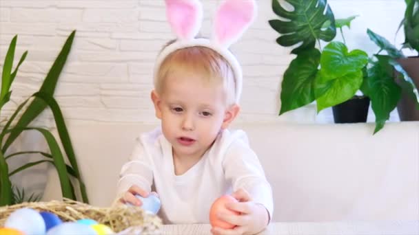 Divertido niño feliz con huevos de Pascua y orejas de conejo bailando y cantando. Concepto de Pascua, infancia feliz. Caza de huevos de Pascua. Movimiento lento. — Vídeos de Stock