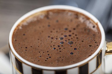 Türk kahvesi ahşap masada. Türk kahvesi geleneksel fincanı, kahve çekirdekleri masaya saçılmış..