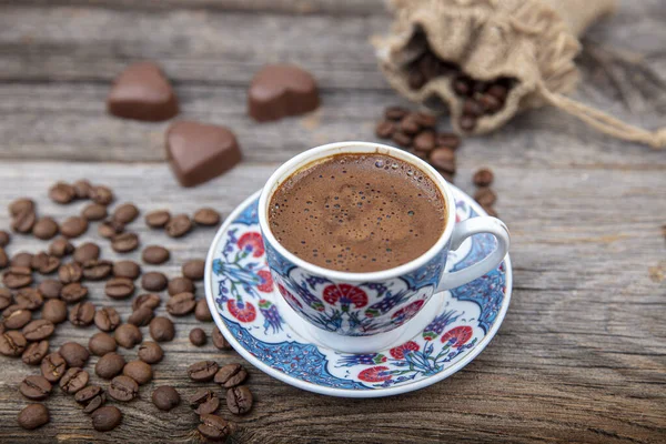 木製のテーブルの上にトルココーヒー トルコのコーヒーセラミック伝統的なカップ テーブルの上に散在するコーヒー豆 — ストック写真