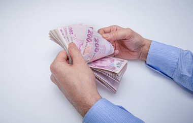 Adam Türk paralarını eliyle sayıyor. Türk lirası banknotları.