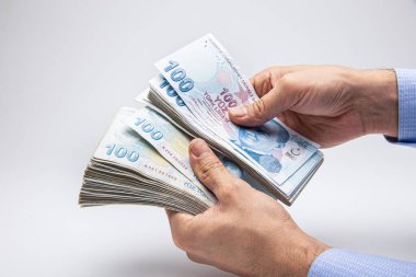 Adam Türk paralarını eliyle sayıyor. Türk lirası banknotları.