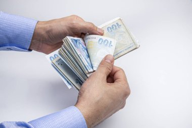 Adam Türk paralarını eliyle sayıyor. Türk lirası banknotları.