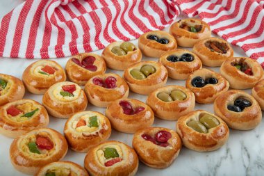 Mini Sosisliler açık büfe olarak servis edildi. Çeşitli sebzeli mini pizzalar, mozzarella peyniri ve mermer arka planda taze fesleğen, yakın plan, üst manzara..