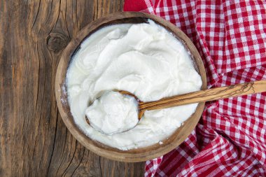 Köy ahşap bir masada ahşap bir kasede Yunan yoğurdu. Seçici odak.