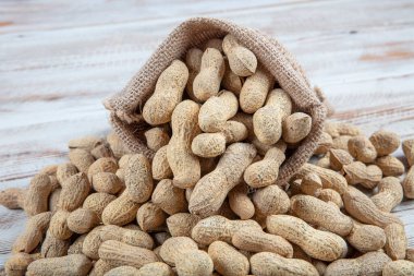 Kabuklu fıstık. Ayrıca yer fıstığı ya da yer fıstığı. Bir yığın kabuksuz, kavrulmuş Arachis hipogaea, atıştırmalık, yağ hasadı ve tahıl sürahisi olarak kullanılır. Makro yemek fotoğrafı. Yukarıdan yakın çekim..