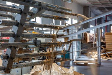 Kağıt tüp çekirdekleri için yapıştırıcı makinesi, çelik metal motor, endüstriyel üretim fabrikasında çalışan teknoloji üreticisi. Ham ürün ekipmanları. Depoda karton kargo.