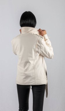 Moda tarzı, moda kadın kıyafetleri, renk kombinasyonu. Beyaz arka planda deri ceketli güzel esmer kız. Modern moda kadın kıyafetleri.. 