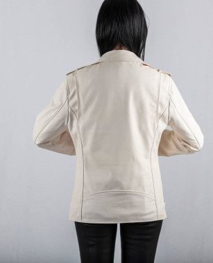 Moda tarzı, moda kadın kıyafetleri, renk kombinasyonu. Beyaz arka planda deri ceketli güzel esmer kız. Modern moda kadın kıyafetleri.. 