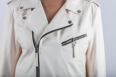 Moda tarzı, moda kadın kıyafetleri, renk kombinasyonu. Beyaz arka planda deri ceketli güzel esmer kız. Modern moda kadın kıyafetleri.. 