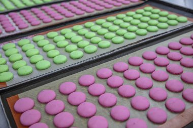 Makaron üretimi. Pembe hamurun hazırlanması. Paslanmaz bir kasede pembe tereyağlı makarna. Modern gümüş mutfak tezgahı karıştırıcısı badem kurabiyesi için hamur karıştırıyor..