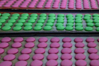 Makaron üretimi. Pembe hamurun hazırlanması. Paslanmaz bir kasede pembe tereyağlı makarna. Modern gümüş mutfak tezgahı karıştırıcısı badem kurabiyesi için hamur karıştırıyor..