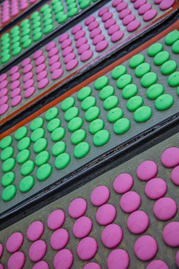 Makaron üretimi. Pembe hamurun hazırlanması. Paslanmaz bir kasede pembe tereyağlı makarna. Modern gümüş mutfak tezgahı karıştırıcısı badem kurabiyesi için hamur karıştırıyor..