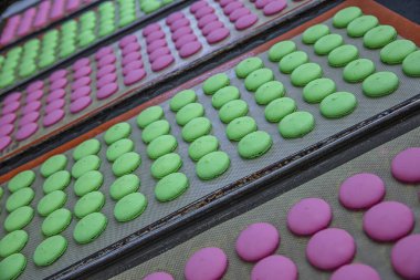 Makaron üretimi. Pembe hamurun hazırlanması. Paslanmaz bir kasede pembe tereyağlı makarna. Modern gümüş mutfak tezgahı karıştırıcısı badem kurabiyesi için hamur karıştırıyor..