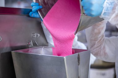 Makaron üretimi. Pembe hamurun hazırlanması. Paslanmaz bir kasede pembe tereyağlı makarna. Modern gümüş mutfak tezgahı karıştırıcısı badem kurabiyesi için hamur karıştırıyor..