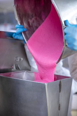 Makaron üretimi. Pembe hamurun hazırlanması. Paslanmaz bir kasede pembe tereyağlı makarna. Modern gümüş mutfak tezgahı karıştırıcısı badem kurabiyesi için hamur karıştırıyor..