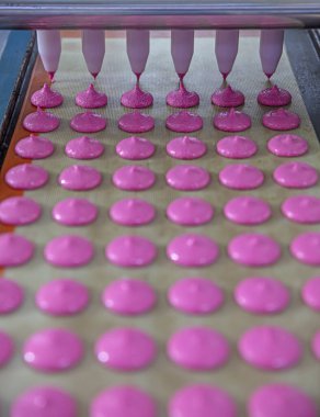 Makaron üretimi. Pembe hamurun hazırlanması. Paslanmaz bir kasede pembe tereyağlı makarna. Modern gümüş mutfak tezgahı karıştırıcısı badem kurabiyesi için hamur karıştırıyor..