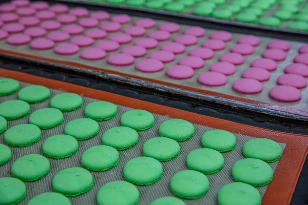 Makaron üretimi. Pembe hamurun hazırlanması. Paslanmaz bir kasede pembe tereyağlı makarna. Modern gümüş mutfak tezgahı karıştırıcısı badem kurabiyesi için hamur karıştırıyor..