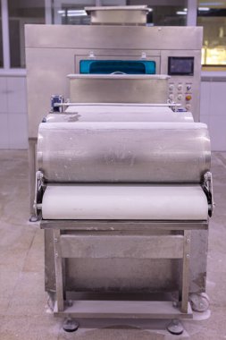 Baker hamur kalıbından hamur işi yapıyor. Hamur, ekmek ve baklava üretimi için hamur rulosu makinesi.