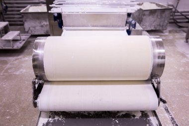 Baker hamur kalıbından hamur işi yapıyor. Hamur, ekmek ve baklava üretimi için hamur rulosu makinesi.