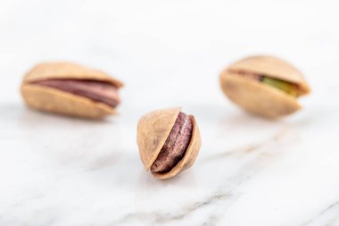 Kabukta şam fıstığı yığını var. Fıstık mermer zemin üzerinde izole.