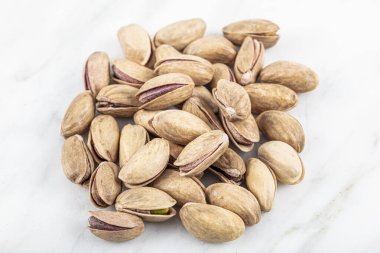 Kabukta şam fıstığı yığını var. Fıstık mermer zemin üzerinde izole.