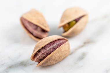 Kabukta şam fıstığı yığını var. Fıstık mermer zemin üzerinde izole.