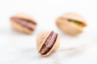 Kabukta şam fıstığı yığını var. Fıstık mermer zemin üzerinde izole.