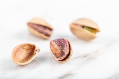 Kabukta şam fıstığı yığını var. Fıstık mermer zemin üzerinde izole.