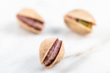 Kabukta şam fıstığı yığını var. Fıstık mermer zemin üzerinde izole.