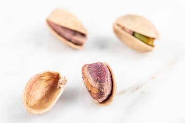 Kabukta şam fıstığı yığını var. Fıstık mermer zemin üzerinde izole.