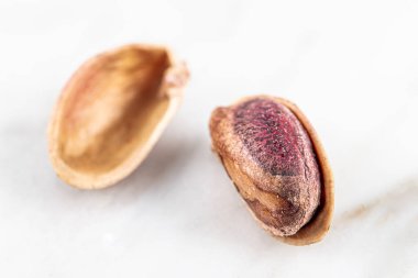 Kabukta şam fıstığı yığını var. Fıstık mermer zemin üzerinde izole.