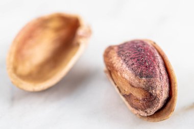 Kabukta şam fıstığı yığını var. Fıstık mermer zemin üzerinde izole.