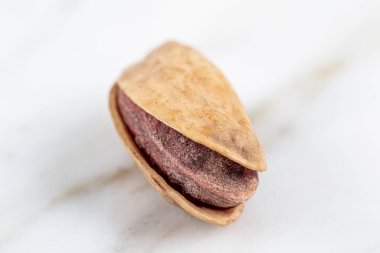 Kabukta şam fıstığı yığını var. Fıstık mermer zemin üzerinde izole.