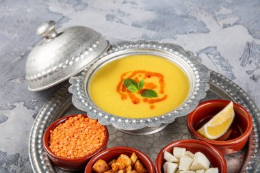 Bakır tepside mercimek çorbası ve gri arka plan. 