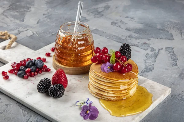 Krepler. Sağlıklı yaz kahvaltısı, ev yapımı klasik Amerikan krepleri taze böğürtlen ve bal ile, sabah üstü gri taşlı arka plan fotokopi alanı