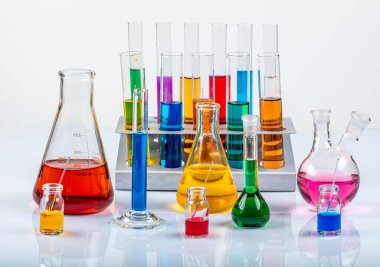 Erlenmeyer, tüpler ve renkli sıvılar içeren ölçüm silindiri gibi cam laboratuvar malzemeleri. Bilim kimyası konsepti. Laboratuvar test tüpleri ve renkli sıvılarla dolu mataralar..