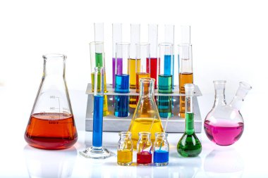 Erlenmeyer, tüpler ve renkli sıvılar içeren ölçüm silindiri gibi cam laboratuvar malzemeleri. Bilim kimyası konsepti. Laboratuvar test tüpleri ve renkli sıvılarla dolu mataralar..