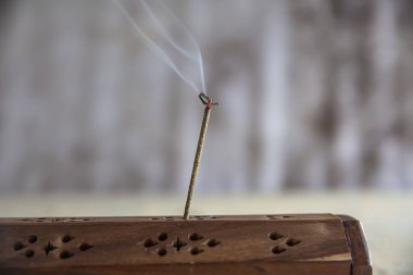 Meditasyon ve rahatlama için yanan tütsü dumanı çubuğu. Yoga konsepti için Aromaterapi dumanı. Asya tütsü çubuğu dumanla yanıyor, yakın..