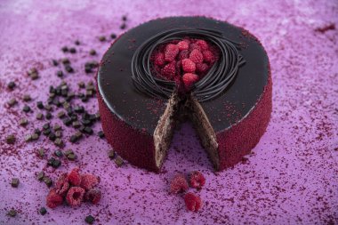 Çikolata genoise katmanlarından yapılmış ahududu pastası ahududu jölesiyle kaplanmış ve yabanmersini ve ahududu ile süslenmiş. Doğum günü pastası. Hediye keki..