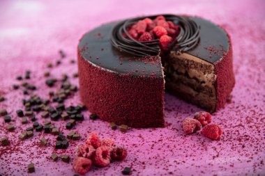 Çikolata genoise katmanlarından yapılmış ahududu pastası ahududu jölesiyle kaplanmış ve yabanmersini ve ahududu ile süslenmiş. Doğum günü pastası. Hediye keki..