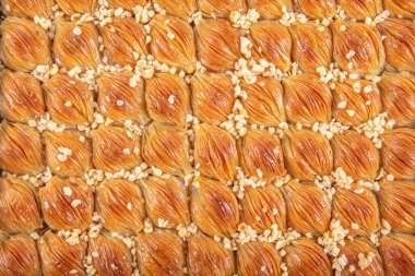 Geleneksel Türk baklavası. Ceviz ve Kremalı Midye Baklava (Mussel Shaped Baklava). İslami Tatil Konsepti. Türkçe adı Midye Baklava. Mermer zemindeki tepside midye baklavası..
