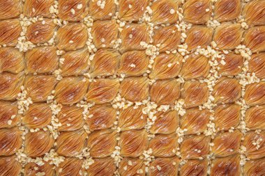 Geleneksel Türk baklavası. Ceviz ve Kremalı Midye Baklava (Mussel Shaped Baklava). İslami Tatil Konsepti. Türkçe adı Midye Baklava. Mermer zemindeki tepside midye baklavası..