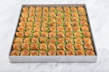 Yeşil şam fıstığı tozu ve tereyağı kremalı Türk Midye Baklava 'sı (Midye Baklava). Midye Baklava 'nın yerel adı.