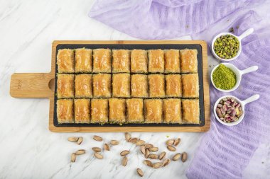 Turkish style pistachio baklava presentation and service. Baklava on a marble floor.