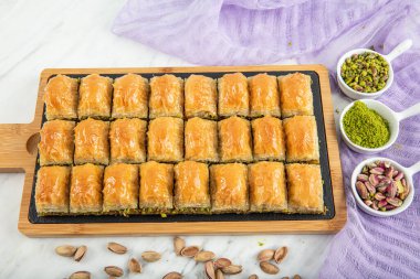 Turkish style pistachio baklava presentation and service. Baklava on a marble floor.