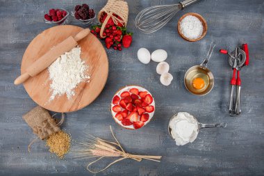 Pasta pişirmek için gerekli malzemeler. Pişirme arka plan afişi. Koyu kırsal bir masada hamur pişirmek için çeşitli malzemeler. Çikolatalı kek ve kurabiye tarifi. Üst manzara, düz uzanma