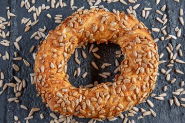 Ayçiçeği tohumlu siyah bir zemin üzerinde ayçiçeği tohumlu simit. Türk Simit, çıtır çıtır.