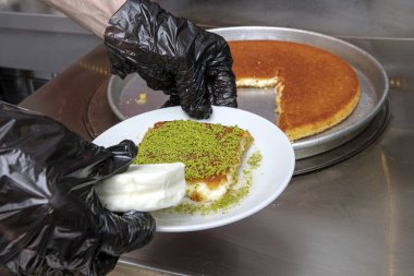 Sıcak servis edilen Türk tatlısı, kunefe, fıstık tozu ve peynir kadayif çok tatlıdır. Geleneksel Türk tatlısı. Şef mutfakta servis için Kunefe tatlısını hazırlıyor..