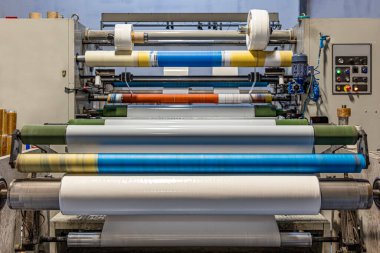 Bant üretim fabrikası. Geri sarma Makinesi. Beyaz parlak kağıt, makinede gerilim, kayma ve kırışıklık ile geri sarar..