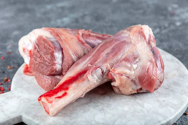 脚の若い子羊の新鮮な生肉 大理石の石の背景に生の子羊の足ハーブ — ストック写真